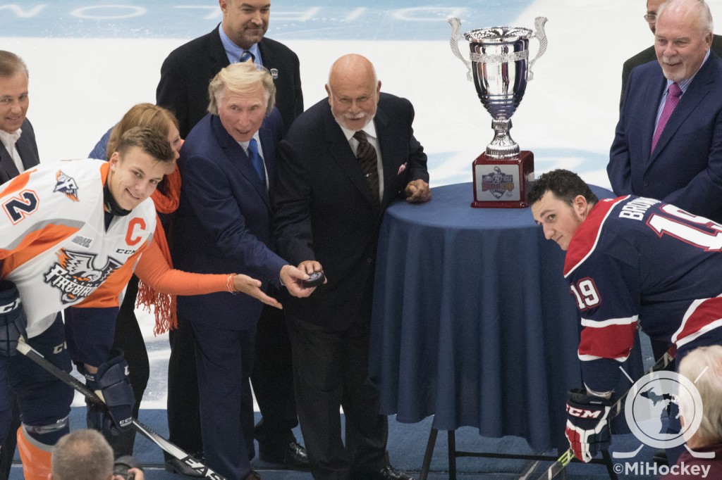 The I-75 Divide Cup next to Firebirds owner Rolf Nilsen and former Plymouth Whalers owner Peter Karmanos, Jr., during a ceremonial puck drop before the Firebirds' first home game. (Photo by Michael Caples/MiHockey